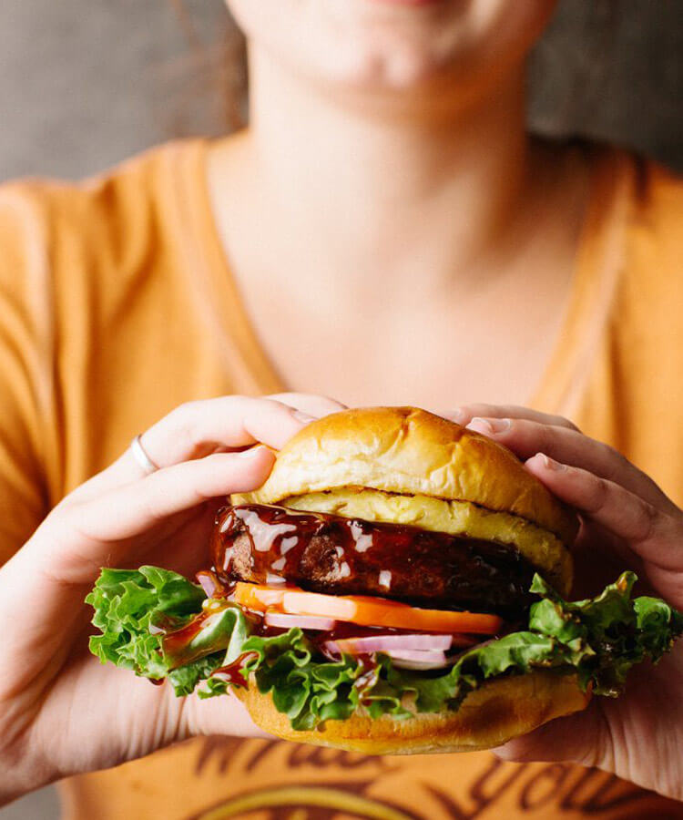 person holding a burger - mobile version