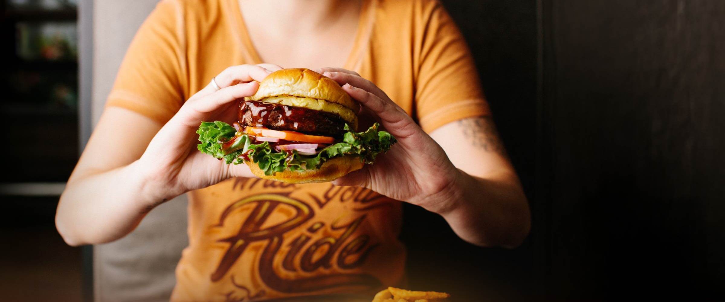 person holding a burger - desktop version